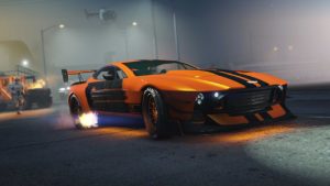 La voiture Dewbauchee Champion poursuivi par la police dans GTA Online, la voiture est de couleur orange, dispose de deux bandes noires qui traversent le véhicule dans la longueur et le pot d'échappement crache des flammes.
