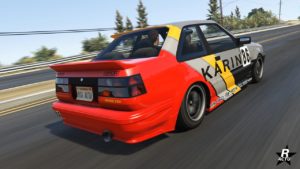Vue arrière du véhicule japonais Karin Futo dans GTA Online, un motif de course de couleurs rouge, gris et jaune se trouve sur la carrosserie, ainsi que la mention "Karin" sur les côtés latéraux.