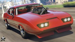 La voiture modifiable chez Benny's, Bravado Gauntlet Classique Custom, vue de l'avant, la carrosserie du véhicule est de couleur rouge et le bloc moteur sort du capot