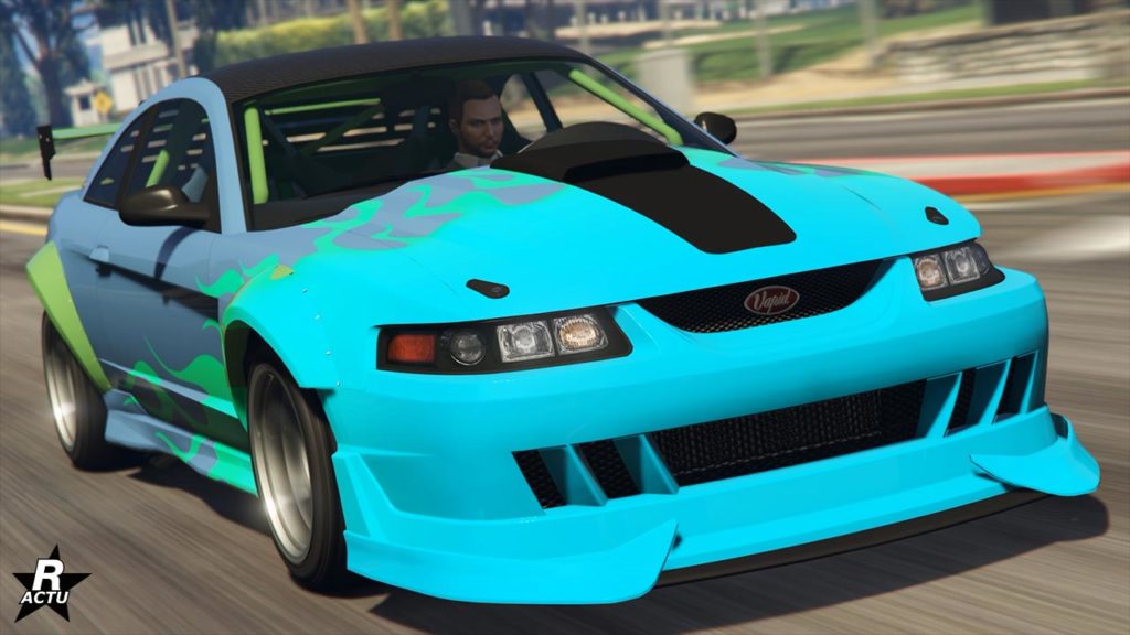 La voiture Vapid Dominator ASP dans GTA Online, elle est de couleur bleue avec un motif de flammes bleues et vertes