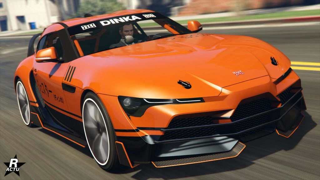Image d’une voiture de sport Dinka Jester RR dans le jeu vidéo GTA Online. La voiture est de couleur orange vif avec des détails noirs et blancs, et présente un design moderne et élégant. Le logo ‘DINKA’ est visible en blanc sur pare-soleil de la voiture. Le véhicule est en mouvement, capturée dans un environnement urbain flou à l’arrière-plan. Les roues sont larges et blanches, donnant à la voiture un aspect robuste et performant.