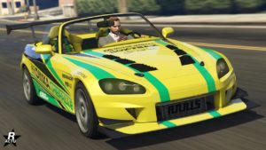 Cette image montre une voiture sportive Dinka RT3000 dans le jeu vidéo GTA Online, vue de l’avant. La voiture est de couleur jaune vif avec des détails verts et noirs, lui donnant un aspect sportif. Elle a un design élégant avec des caractéristiques aérodynamiques, y compris un grand aileron à l’arrière. Le capot de la voiture présente des aérations en carbone. Un personnage du jeu se trouve dans le siège du conducteur, portant une tenue formelle. L’environnement autour du véhicule est une rue de la ville du jeu pendant la journée, des bâtiments et des arbres sont visibles en arrière-plan flou. Il y a des logos et du texte sur le côté de la voiture, y compris ‘DINKA’, ‘MEINMACHT’, ‘PRO Lap’ indiquant des autocollants de marque et de parrainage typiques des voitures de course.