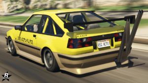 Une voiture de sport à deux portes, la Karin Futo GTX, en jaune et beige, est en mouvement sur une rue dans le jeu vidéo GTA Online. La voiture a des caractères japonais écrits sur le côté, et les logos ‘KARIN’ et ‘TOFU’ sont visibles. Elle dispose d’un grand aileron noir à l’arrière, qui renforce son apparence sportive. La plaque d’immatriculation indique ‘RSG ACTU’. Un conducteur est visible à l’intérieur de la voiture, bien que l'habitacle du véhicule ne soient pas distinctes, mais ont peut tout de même voir des arceaux de sécurité.