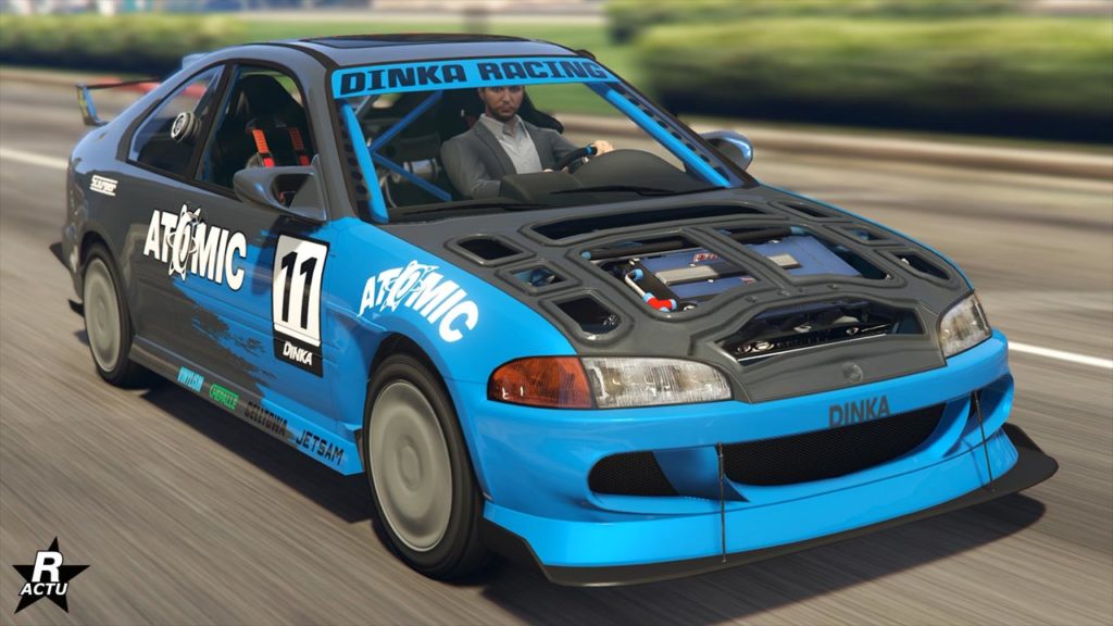 Vue avant d’une voiture de course Dinka Kanjo SJ bleue et grise dans le jeu vidéo GTA Online. La voiture est ornée d’autocollants de sponsors tels que ‘ATOMIC’ et ‘DINKA RACING’, et elle est en mouvement sur une rue de Los Santos. Le numéro 11 est affiché en blanc sur un fond noir sur le côté de la voiture. Le capot ouvert révèle des détails mécaniques internes. Un personnage du jeu, portant un costume gris, est visible à l’intérieur, conduisant la voiture.