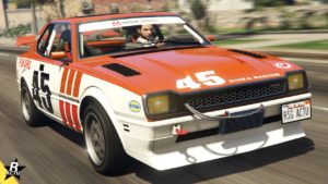Vue avant d’une voiture Dinka Postlude dans le jeu vidéo GTA Online. La voiture est de couleur orange vif avec des détails blancs. Le numéro ‘45’ est affiché en gros sur le capot et la porte du côté conducteur. Des autocollants de sponsors et logos, y compris ‘DINKA RACING’, sont visibles sur la carrosserie. La plaque d’immatriculation indique ‘RSG ACTU’. La voiture est équipée d’un pare-chocs sportif et d’une grille avant noire.