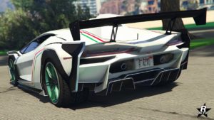 Vue arrière de la Pegassi Ignus armée blanche avec des détails verts sur les jantes et les couleurs du drapeau italien sur la carrosserie. La voiture est présentée dans un environnement verdoyant. La plaque d’immatriculation indique ‘R ACTU’.