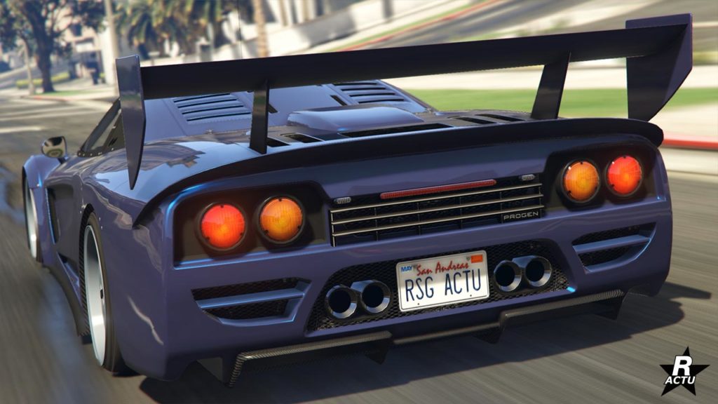 Vue arrière d’une voiture Progen Tyrus dans un environnement du jeu vidéo Grand Theft Auto Online. La voiture est représentée avec un grand aileron arrière, des feux arrière circulaires distinctifs, et un design agressif avec des évents et des grilles à l’arrière. La plaque d’immatriculation indique “RSG ACTU” qui est l'acronyme de notre site internet, Rockstar Actu.