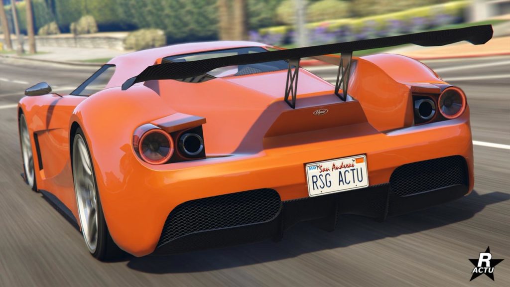 Vue arrière d’une voiture de sport Vapid FMJ de couleur orange en mouvement sur une route dans GTA Online. La voiture présente des feux arrière circulaires, un aileron arrière proéminent pour la force d’appui, des pots d’échappement doubles et une plaque d’immatriculation indique ‘RSG ACTU.