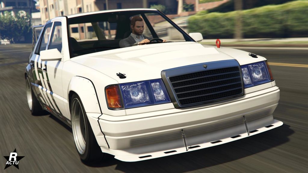 Vue avant de la Benefactor Vorschlaghammer dans Grand Theft Auto Online. Il s'agit d'une voiture de type berline peinte intégralement en blanc et avec un motif de bandes grises en biais à l'arrière du véhicule.