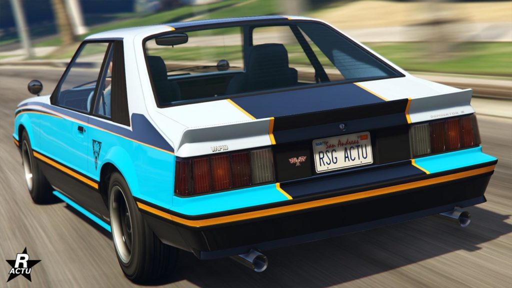 La voiture Vapid Dominator FX dans le jeu vidéo GTA Online, vue de derrière. Elle a un trio de couleurs sur sa carrosserie : bleu vif, blanc et jaune. Sur le coffre, un aileront en forme de bec de canard y est présent.