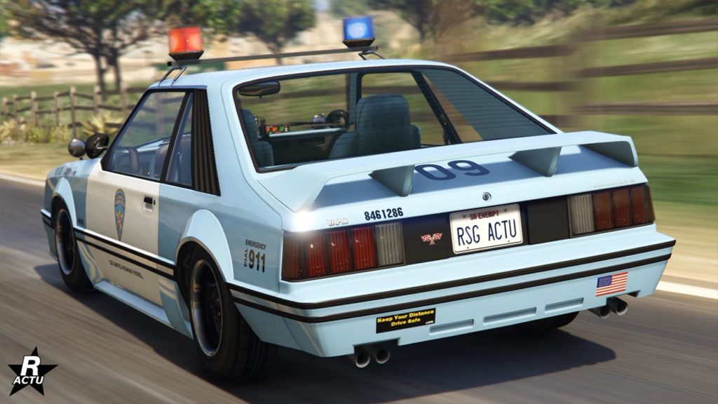 Vue arrière de la Vapid Dominator FX Interceptor, la voiture de police des années 80' est de couleur bleue ciel, et blanc pour ses portes. Un aileron de taille moyenne se trouve sur le toit du coffre à l'arrière.