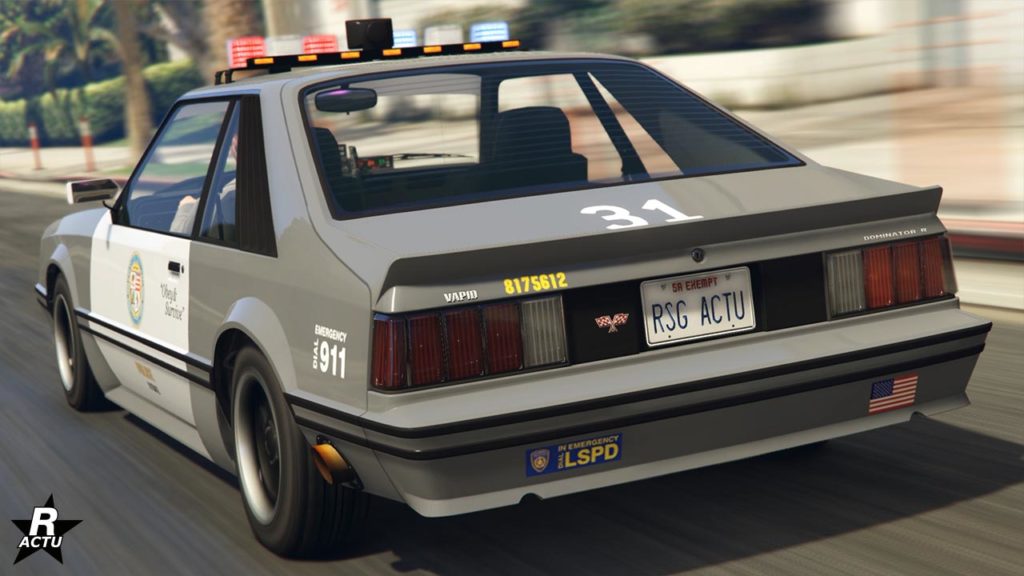 La voiture de flic Vapid Dominator FX Interceptor dans le jeu vidéo GTA Online, le véhicule est vue de derrière. Elle est peinte en gris clair et blanc pour ce qui est ses portières qui affichent le logo de la police de Los Santos.