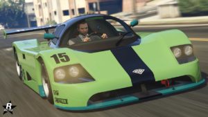 Vue avant d’une voiture de course vert lime et blanche, portant le numéro 15, dans le jeu vidéo GTA Online. Le véhicule est modelé d’après une voiture de sport haute performance avec des caractéristiques distinctives telles qu’une position basse et large, de grandes prises d’air à l’avant, et un aileron arrière proéminent pour l’aérodynamique. Le logo Benefactor est visible sur le devant de la voiture, indiquant sa marque dans le jeu, le modèle du véhicule et quant à lui la LM87.