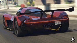 Vue arrière d’une voiture de sport moderne Dewbauchee Vagner rouge du jeu vidéo GTA Online en mouvement. La voiture présente un aileron arrière proéminent, des feux arrière distinctifs et des tuyaux d’échappement doubles. Il y a aussi une plaque d’immatriculation qui indique ‘RSG ACTU’. Le design de la voiture suggère une haute performance et une grande vitesse.