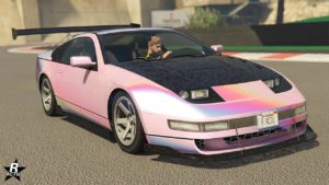 L’image montre une voiture, l'Annis Euros X32, la couleur de sa carrosserie est un gradient rose et blanc. Le véhicule est représenté dans un environnement de jeu vidéo, GTA Online plus précisément.
