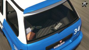 Vue du coffre de la voiture Bravado Dorado Cruiser vue depuis le pare-brise arrière, on y voit un gilet pare-balles et des équipements de police.