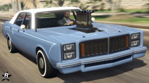 Vue avant de la voiture américaine Bravado Greenwood, elle est de couleur bleue nautique et blanche pour son toit. Différents tuyaux sortent du bloc moteur par le capot.