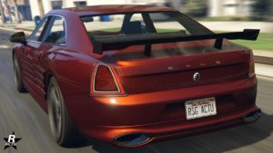 Image arrière du véhicule Enus Deity dans GTA Online, la voiture est peinte en rouge foncé et elle a un aileron en carbone attaché sur son coffre.