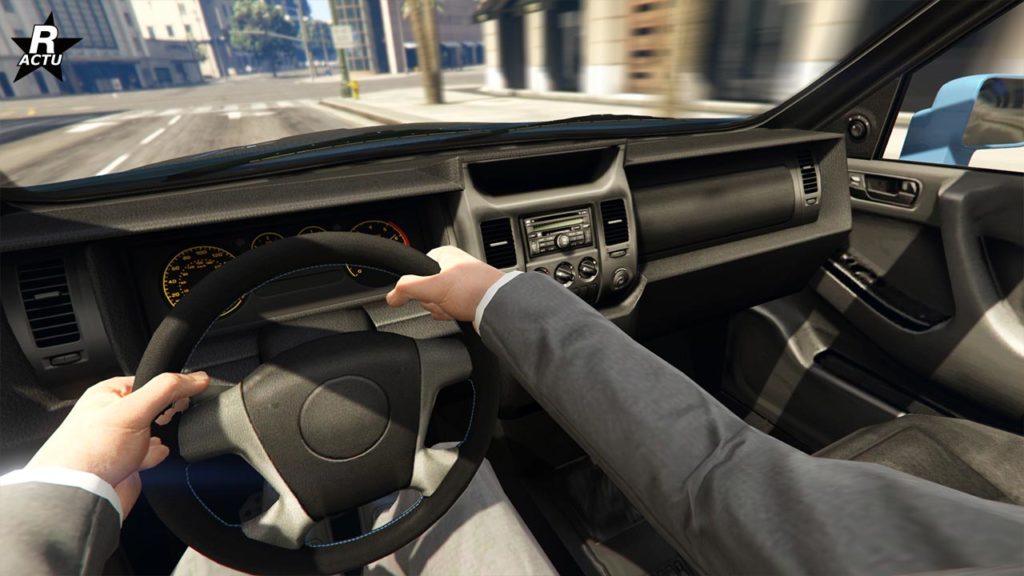 Image dévoilant l'intérieur de la voiture britannique Enus Jubilee dans GTA Online. L'image est présentée comme un point de vue du conducteur, dévoilant son habitacle qui est typique des voitures des années 2000, avec peu de raffinement et une station de radio dans la console centrale.