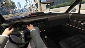 Image d'un point de vue du conducteur conduisant la voiture Albany Lurcher dans GTA Online. Le tableau de bord est assez classique et les compteurs analogiques derrière le volant sont incrustés dans un panneau en carbone.