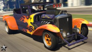 Image de l'Albany Fränken Stange dans GTA Online vue de devant. Le véhicule est un hot road américain du début du vingtième siècle. La carrosserie est peinte en mauve et en orange pour ses garde-boue. Une décalcomanie d'un motif de flammes jaunes se trouve à l'avant de la voiture et se propage vers l'arrière. Le bloc moteur est visible, dû au fait qu'aucun capot n'est présent sur le véhicule.