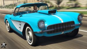 La voiture Invetero Coquette D1 vue de devant, elle est peinte en bleue avec des notes de blancs sur les cotés latéraux. Sur le capot, une grande aération d'air dépasse et les phares ont des décorations en forme de cils.