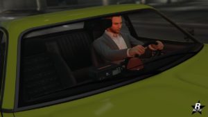 Vue rapprochée de l'habitacle avant depuis l'extérieur du véhicule Bravado Greenwood Cruiser, on y voit un petit gyrophare rouge posée sur le tableau de bord, le gyrophare est allumé et illumine en rouge le personnage de GTA Online qui conduit la voiture.