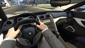 Vue de l'intérieur de la supersportive Ocelot XA-21 dans le jeu GTA Online. La vue est du point de vue du conducteur, on y voit clairement l'habitacle intérieur où des éléments du tableau de bord est gris anthracite avec des notes de blanc. La voiture dispose d'une console centrale affichant sur un écran le nom de la radio.