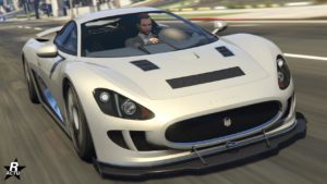Image de la voiture britannique Ocelot XA-21 dans le jeu vidéo GTA Online. La carrosserie du véhicule est peinte en gris clair, son capot dispose de plusieurs prises d'air et elle a un séparateur en carbone au niveau du pare-chocs avant.