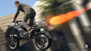Image arrière de la moto Pegassi Oppressor dans GTA Online, les ailes sont déployées et le réacteur à l'arrière qui sert de boost est activé, tout en crachant une flamme énorme.