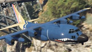 Vue de l'avant de l'avion gros porteur "Eberhard Titan 250D" dans GTA Online. Le véhicule s'inspire de l'avion militaire AC130. La carlingue est de couleur bleue et une décalcomanie de requin se trouve à l'avant de l'avion.