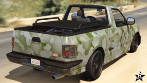 Vue arrière du véhicule Vapid Firebolt ASP present dans le jeu vidéo GTA Online. Le tout-terrain est peint en gris clair avec un camouflage militaire, le plateau arrière dispose d'une barre de toit.