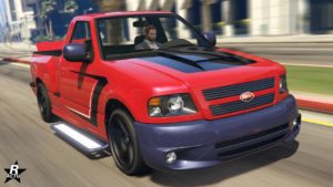 L'avant de la voiture Vapid Firebolt ASP dans GTA Online, sa peinture est de couleur rouge et une décalcomanie de formes géométriques noires sont présentes sur le capot et les côtés latéraux.