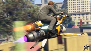 Vue de l'arrière du véhicule volant Pegassi Oppressor Mk II dans le jeu multijoueur GTA Online de Rockstar Games. La moto dispose de deux réacteurs qui sont visibles à l'arrière, ils sont tous les deux activés, l'un des réacteurs fait surgir une flamme bleue, tandis que le second une flamme jaune. Le véhicule est quant à lui recouvert d'un motif de camouflage militaire de couleurs jaune, blanc et noir.