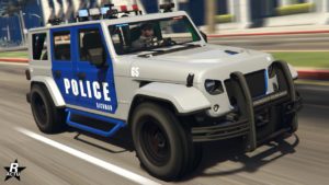 L'avant de la voiture tout-terrain de police Canis Terminus de patrouille dans le jeu GTA Online. Sa carrosserie est peinte en grise à l'exception de ses portières qui sont bleues. Le véhicule se trouve en circulation dans le quartier de Rockford Hills dans Los Santos, sur ses portes latérales, on peut apercevoir une décalcomanie indiquant qu'il s'agit d'un véhicule de police du quartier de Rockford Hills.