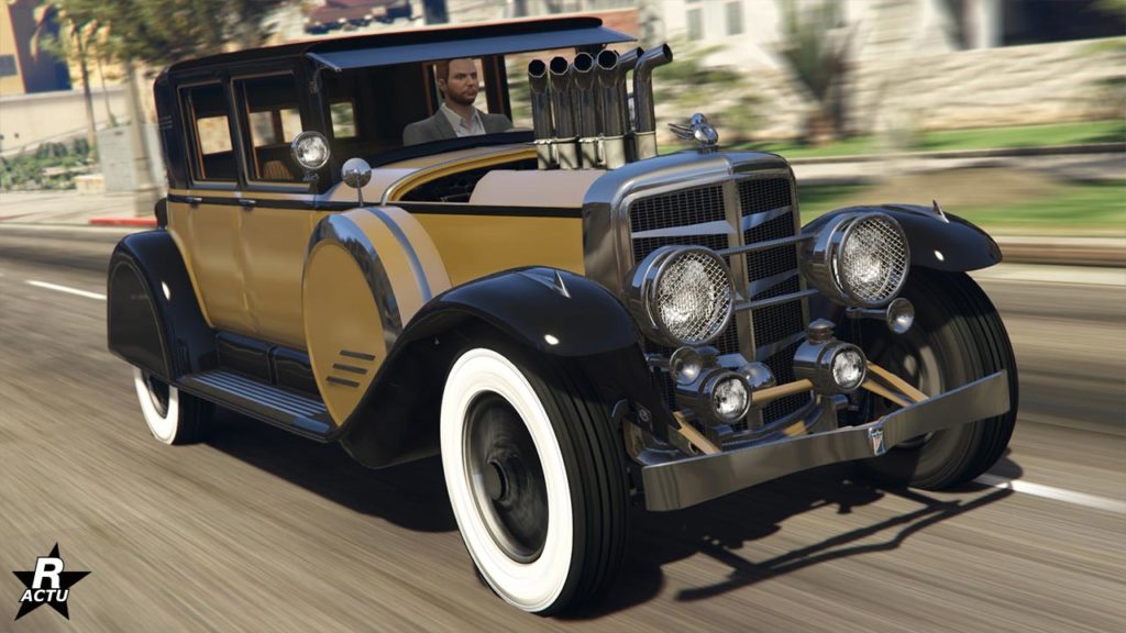 Vue avant du véhicule ancien Albany Roosevelt Valor dans GTA Online. La voiture dispose d'une peinture en or sur sa partie principale, tandis que la partie secondaire est peinte en noire. Sur le capot, des tuyaux permettant de refroidir le moteur dépassent du capot.