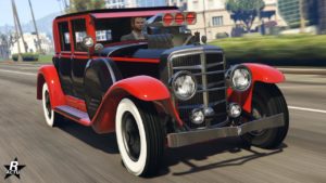 L'avant de la voiture ancienne des années 1920 Albany Roosevelt Valor dans GTA Online. La sportive classique dispose d'une double peinture, rouge pour les garde-boue et le haut des portières, et en noir pour tout le reste de la carrosserie. Sur le capot, un turbocompresseur du moteur dépasse.