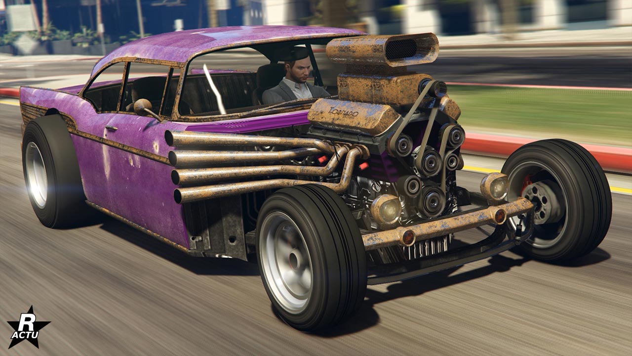 Image de l'avant de la voiture américaine Declasse Tornado rat rod, il s'agit d'un hot rod dans le jeu GTA Online. La carrosserie du véhicule est intégralement de couleur violette, tandis que l'intégralité du moteur est ouvert sur l'extérieur, des pots d'échappements en forme de papillon s'échappent des côtés latéraux du bloc moteur.