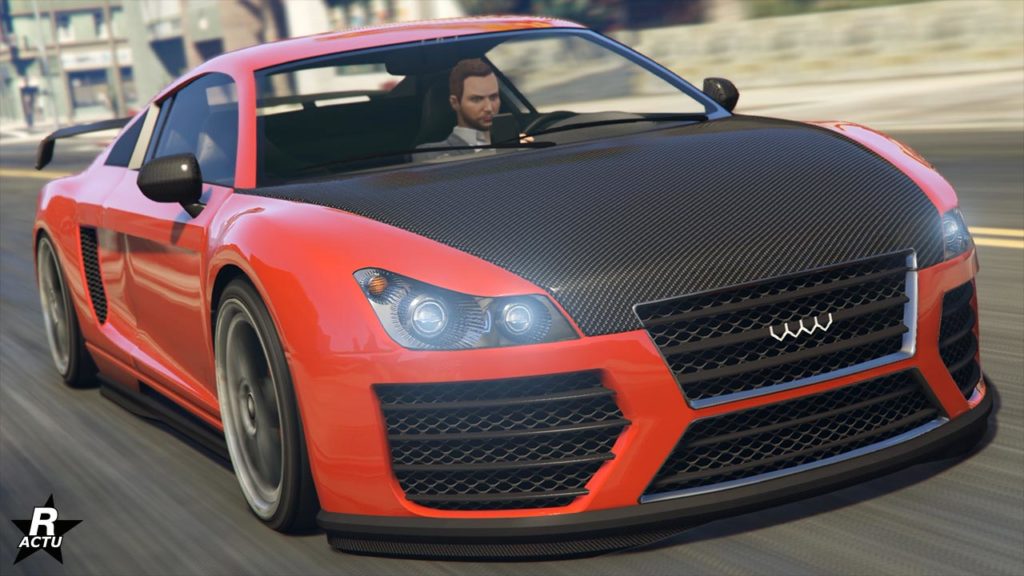 Vue avant de la voiture allemande 9F. Le véhicule de sport est peint en rouge vif, à l'exception de son capot qui est fait de fibre de carbone noire. Les rétroviseurs sont également en carbone. Le bolide se trouve en mouvement sur une route de GTA Online, comme en témoigne le flou de mouvement autour de la 9F.