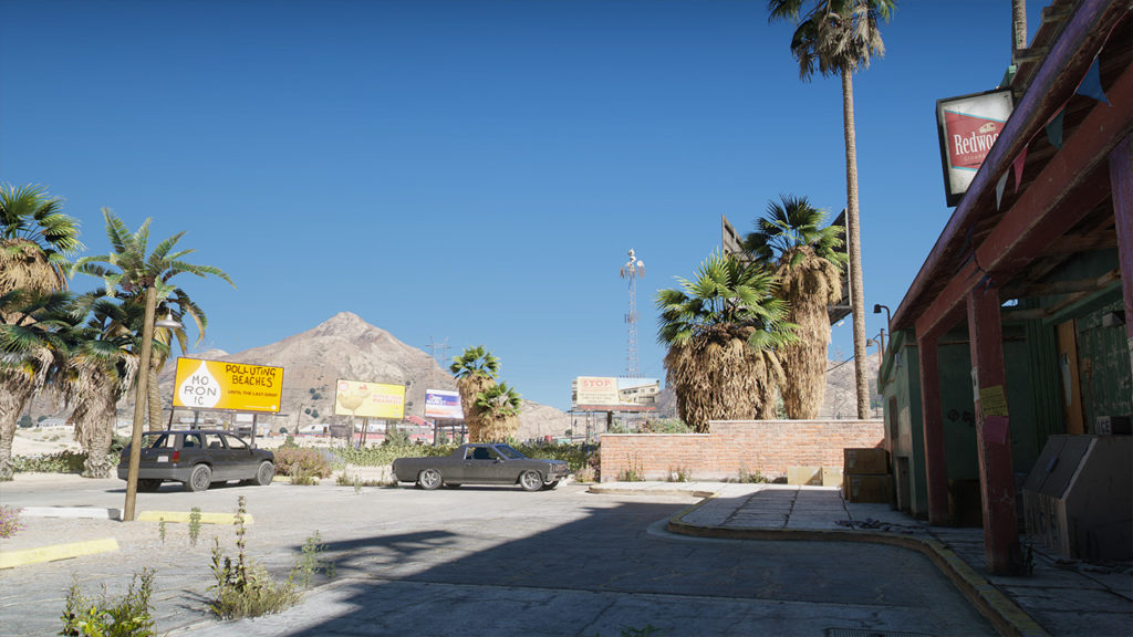Vue extérieur depuis le parking du Yellow Jack Inn qui reflète son ombre sur le sol, tandis que le ciel ensoleillé illumine le reste de la zone.