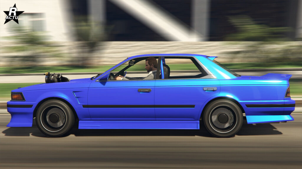 Vue latérale de la berline japonaise des années 1990 qui est peinte intégralement en bleu.