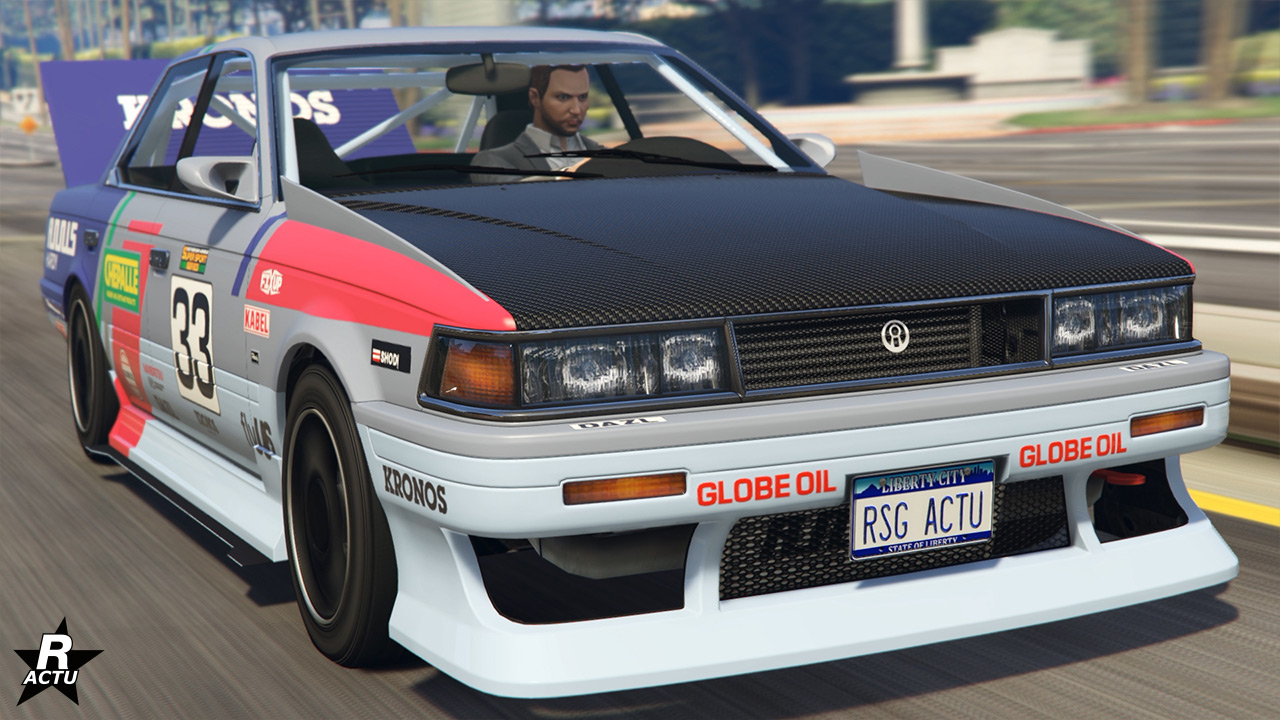 Vue avant du véhicule Annis Hardy sur une route du jeu vidéo Grand Theft Auto Online. La berline s'inspire du design de la Nissan Laurel de sixième génération. Sa carrosserie est blanche, son capot est quant à lui en carbone.