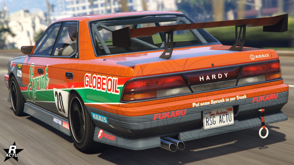 Face arrière du véhicule ancien Annis Hardy dans le jeu de Rockstar Games, Grand Theft Auto Online. Sa carrosserie est peinte en gris métallisé et en orange, avec divers autocollants de course.