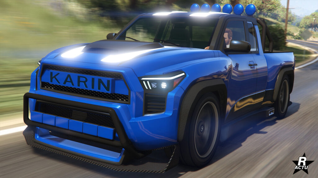 Vue avant du bolide au look agressif Karin Everon RS dans le jeu GTA Online. La voiture japonaise de type SUV est peinte en bleu électrique avec une double bande blanche sur le capot et le toit, qui lui, a six projecteur au-dessus de la cabine.
