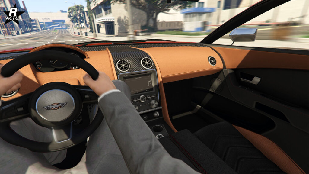 Point de vue du conducteur lors de la conduite de la Dewbauchee Rapid GT X sur une route de GTA Online. La console centrale est fait de fibres de carbone, tandis que le reste du tableau de bord est en tissu de couleur saumon.