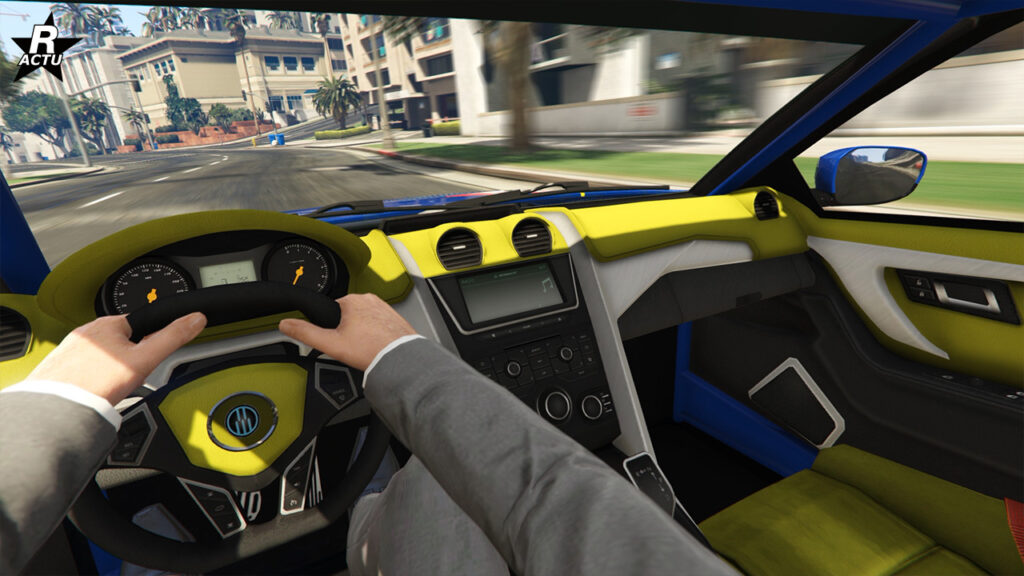 Point de vue du joueur lors de la conduite du bolide sur une route de GTA Online. La partie supérieure du tableau de bord est de couleur jaune, tandis que la seconde partie inférieure est blanche. L'habitacle possède également des arceaux de sécurité peints en bleu.