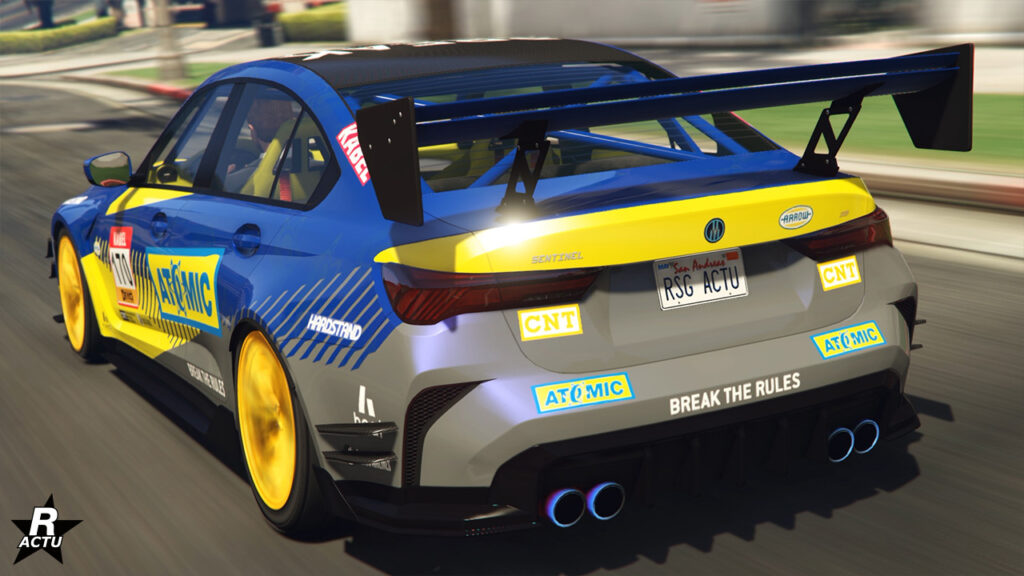 L'arrière de la Sentinel GTS dans GTA Online, sa carrosserie est peinte ne bleu et possède des décalcomanies de course automobile. Sur le coffre se trouve un aileron GT géant en carbone.