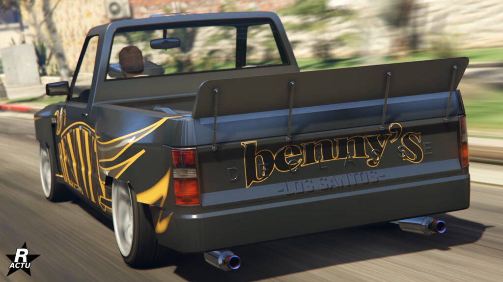 Vue arrière du bolide Walton L35 version drift. Le pick-up de GTA Online est de couleur gris foncé avec un autocollant jaune "Benny's" sur le rabattant