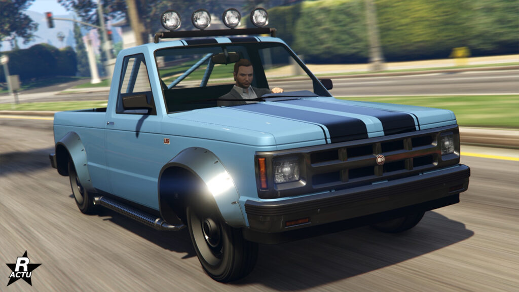 Vue avant du Pick-Up Walton L35 dans sa version "de série". Le véhicule tout-terrain dispose d'une peinture bleu ciel avec une double bande noire sur le capot, ainsi que des projecteurs sur son toit.