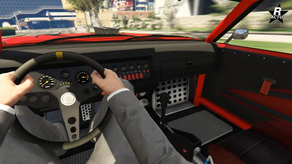 Point de vue du conducteur au volant de la version drift de la Tampa. Le tableau de bord dispose de nombreux compteurs analogiques et de boutons sur sa console centrale, tandis que des arceaux de sécurité rouges entourent l'habitacle et que des panneaux en fibres de carbone recouvrent les portières.